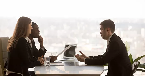 Drei Geschäftsleute sitzen zum Interview im Büro