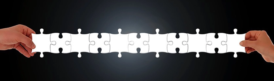 Zwei Hände halten Reihe aus Puzzleteilen Hintergrund schwarz