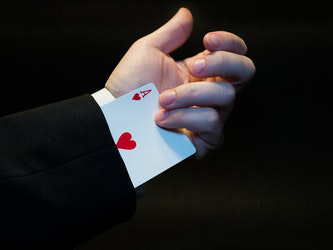 Spielkarte Herz Ass ragt aus Ärmel Hand greift