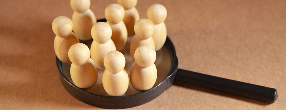Ihre Wunschkandidaten genau im Blick Lupe mit Holzfiguren: Symbol für gezielte Kandidatensuche