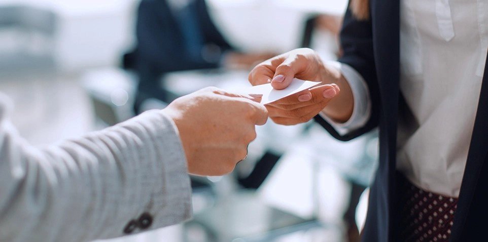 professioneller Austausch von Visitenkarten als Sinnbild für „Was ist Headhunting?“